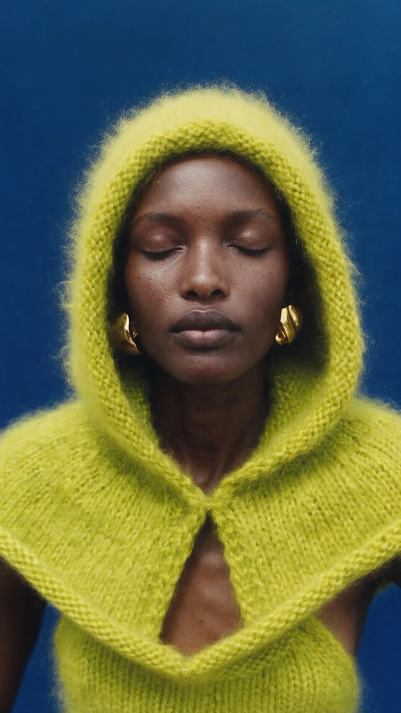 A portrait in a bright yellow knitted hood